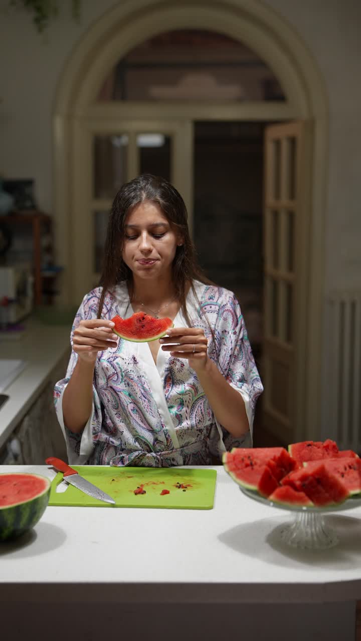 mujer comiendo sandía en la cocina