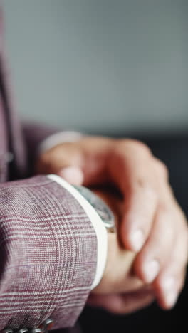 businessman in elegant grey suit checks up time looking at expensive wristwatch in office closeup slow motion. hurrying up man at workplace. corporate life