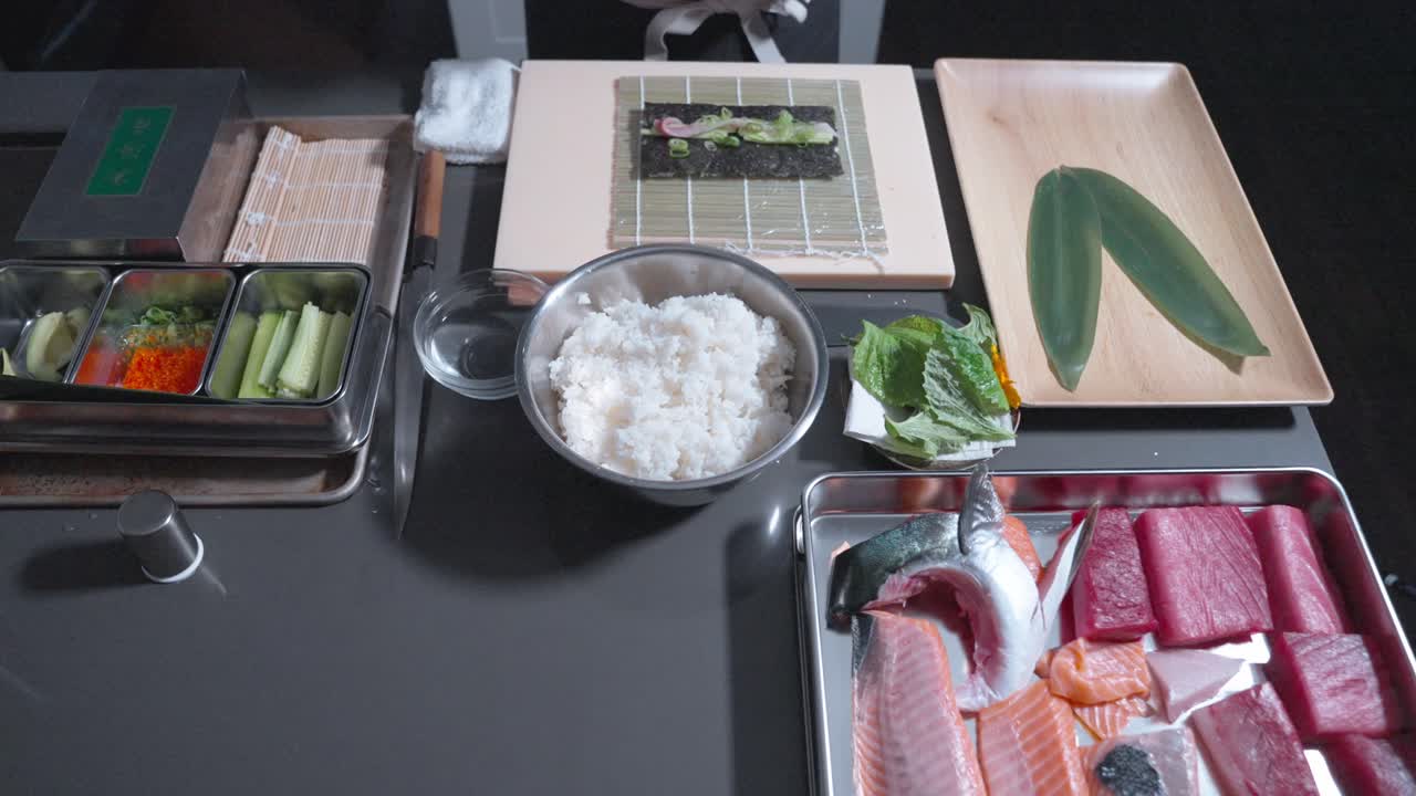 A static shot of a chef using a tool to carefully pack sushi ingredients into a roll before making precise cuts, showcasing the technique and precision involved in sushi preparation.