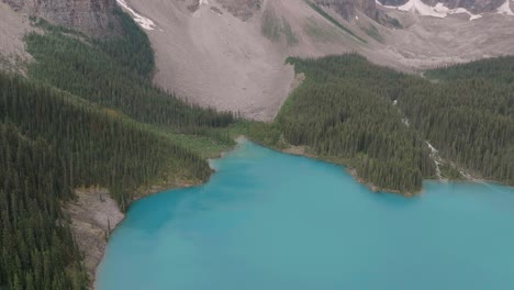 dolly aéreo en bajada en el lago esmeralda moraine, bosque de pinos y montañas en el parque nacional de banff, alberta, canadá