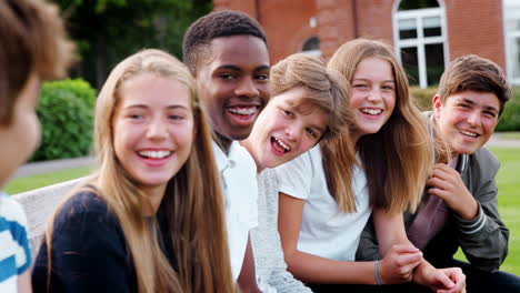 group of teenage students socializing outside school buildings