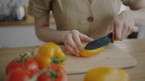 woman cutting yellow bell peppers