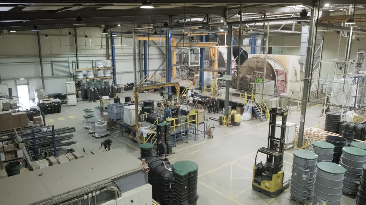 Personas trabajando en una planta de fabricación de moldeo rotacional industrial.
