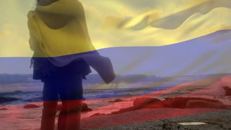 animación de la bandera de colombia sobre una pareja afroamericana en la playa