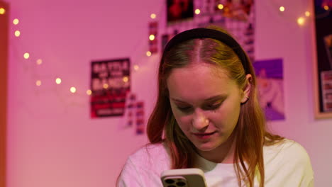 young woman smiling while looking at her phone