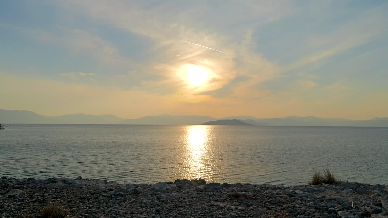 배경 에 산 들 이 있는 바다 위 의 일몰