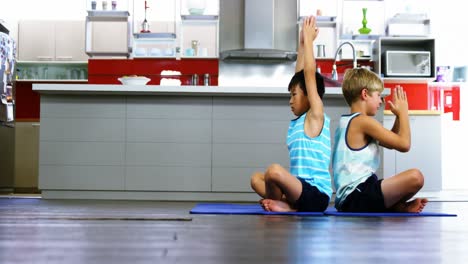 hermanos practicando yoga en la cocina
