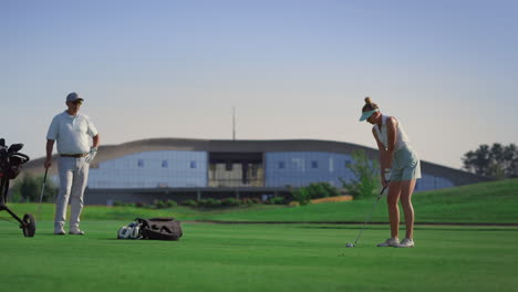 Jugadores-Del-Equipo-De-Golf-Golpeando-La-Pelota-En-El-Club-De-Campo-De-Golf.-Pareja-Disfruta-De-La-Actividad.