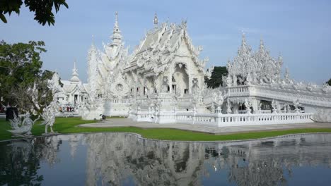 Movimiento-Frontal-En-El-Templo-Blanco-Sobre-El-Lago-Principal,-Chiang-Rai,-Tailandia