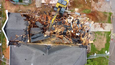 un disparo de un avión no tripulado de arriba hacia abajo de una excavadora derribando un edificio