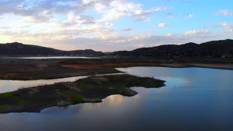 Wide-fly-over-of-island-and-low-water-levels-of-dried-up,-drought-stricken-Irvine-Lake-reservoir-in-Southern-California-with-aerial-drone-4k