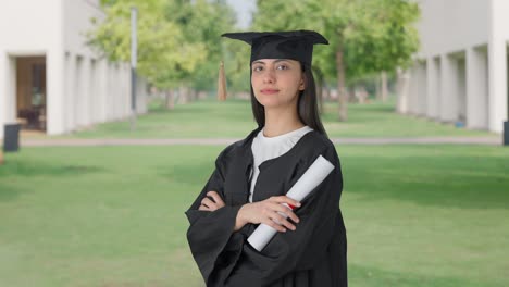 retrato de una chica graduada de la universidad india de pie con las manos cruzadas