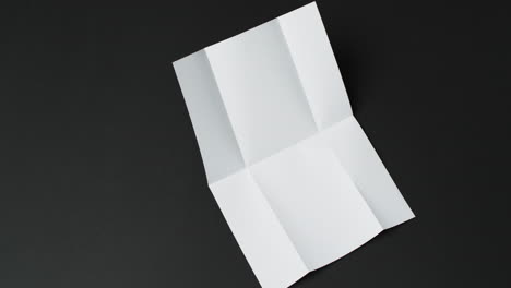 Video-of-piece-of-white-paper-with-creases-on-black-background