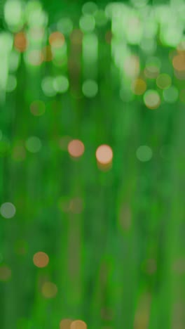 vertical video defocused full frame background shot of green and gold tinsel in studio for st patrick's day