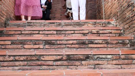 people ascending brick stairs at ayutthaya pagoda