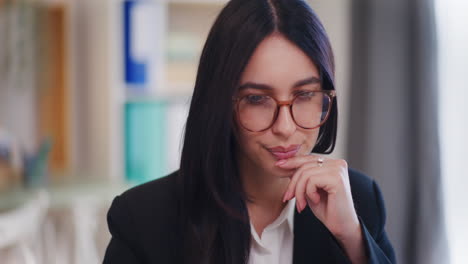 mujer concentrada trabajando en la computadora en la oficina