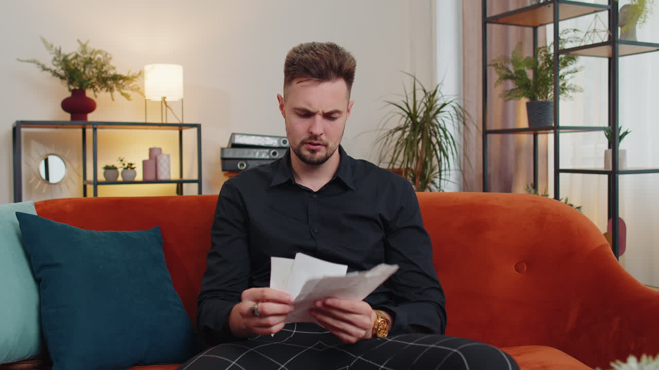 joven estresado mirando a la deuda bancaria no pagada préstamo, haciendo papeleo, planificación del presupuesto, lanza facturas