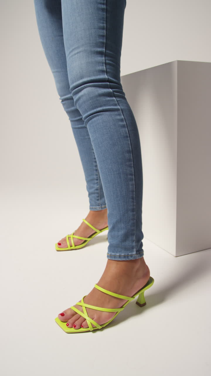 video vertical de cerca de una mujer influyente en las redes sociales produciendo contenido generado por el usuario con un hermoso par de zapatos verdes