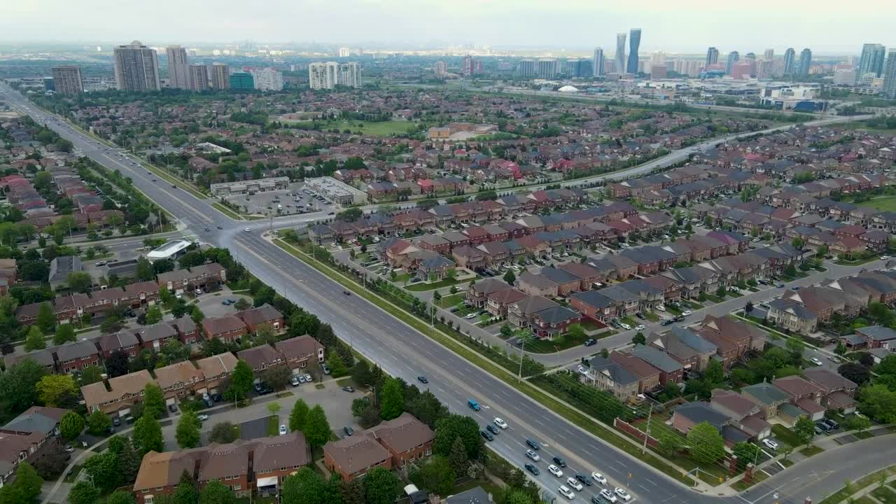 Volando verso il centro città di Mississauga con grandi edifici e molte case