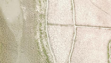 dry cracked drought fractured agricultural land sections aerial view over barren damaged landscape