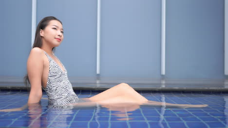 Joven-Mujer-Asiática-Pequeña-En-Traje-De-Baño-Disfrutando-En-El-Agua-De-La-Piscina-Del-Hotel