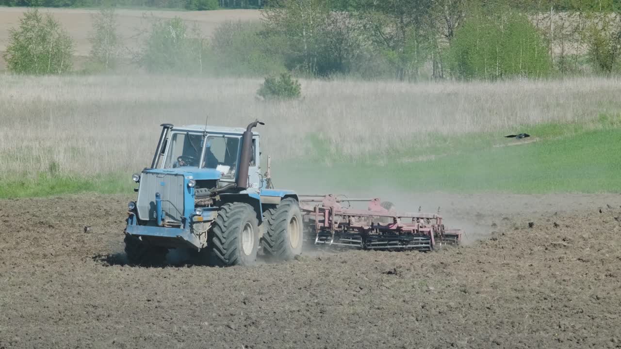 un tractor arando un campo agrícola seco, preparando la tierra para la siembra. industria agrícola. procesamiento del campo en la granja.