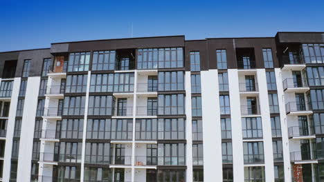 front view of a beautiful multi-storey building. modern design of high-raised apartment building with many glass windows and balconies. aerial view.