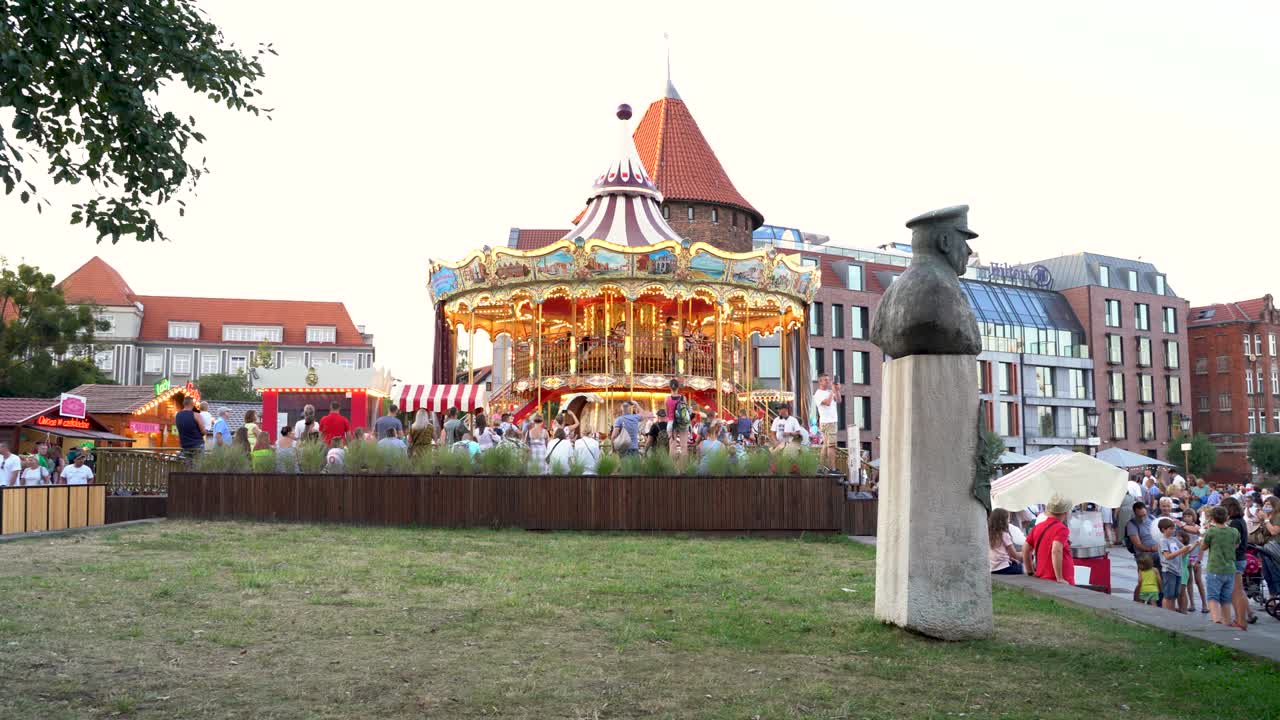 Pan shot of a children enjoying ride in carousel located next to Motlawa river right after covid 19 pandemic