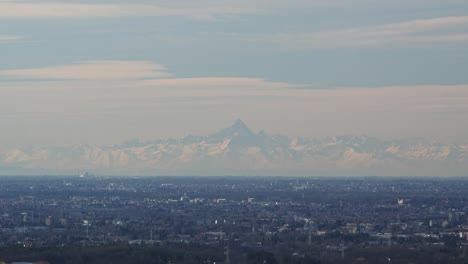 Monte-Monviso-A-Lo-Lejos-Y-La-Ciudad-De-Lombardía-Abajo,-Vista-Aérea-Estática