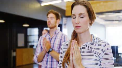 business people performing yoga on floor