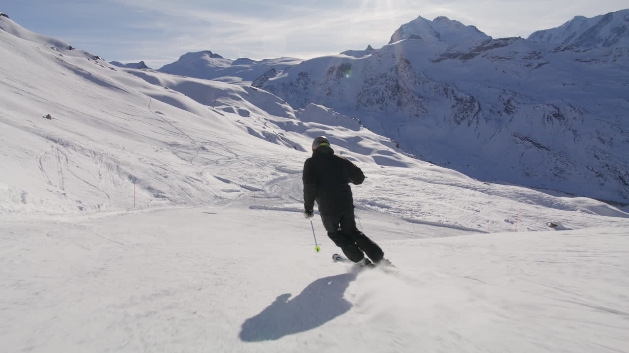 Skiing in Zermatt under the Matterhorn during a blue bird day and perfect slopes. High performance carving on skis.