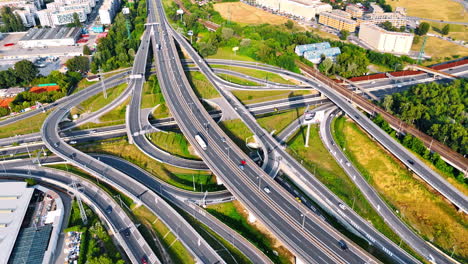 busy highway interchange in europe. vehicles navigate a complex highway interchange with greenery and buildings nearby during daytime in europe