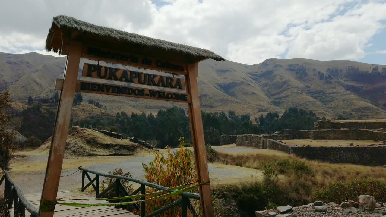 Entry gate and ancient stone ruins of Puka Pukara in Cusco, Peru. Pan right reveal shot of military fortress ruins on the old Pisac Cusco road