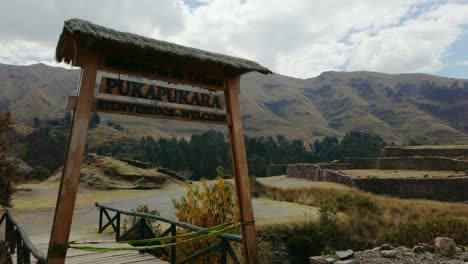 entry gate and ancient stone ruins of puka pukara in cusco, peru. pan right reveal shot of military fortress ruins on the old pisac cusco road