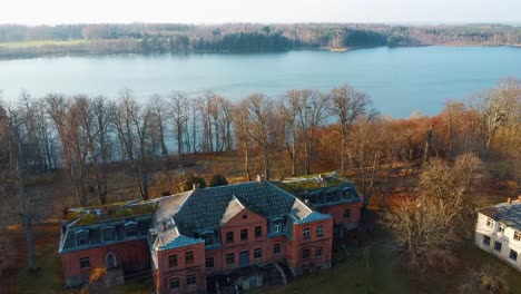 old red brick house, katvari manor in latvia and katvaru lake in the background