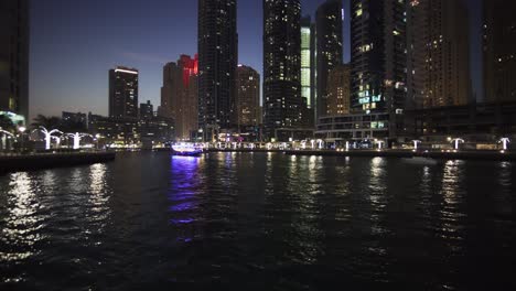 boat with plenty of lights in dubai marina at the night