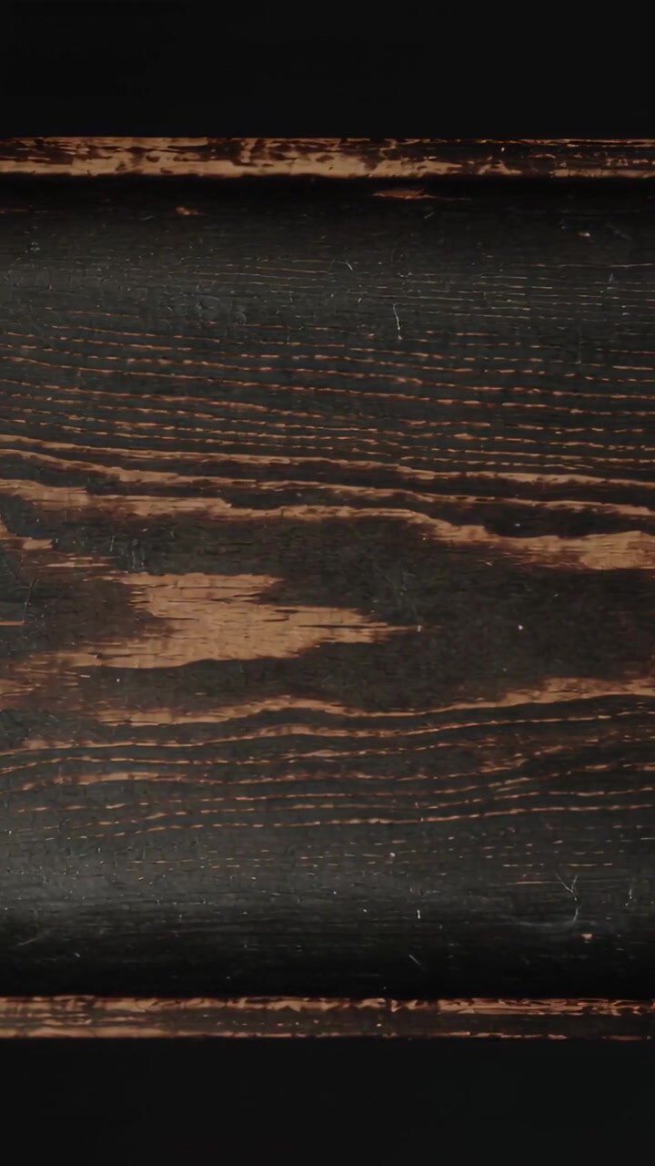Vertical video: Showing camera recording dark stained plank in studio, revealing worn knot and trim