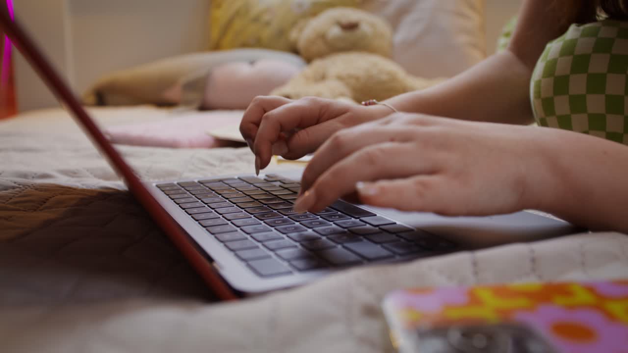 mujer escribiendo en la computadora portátil en la cama