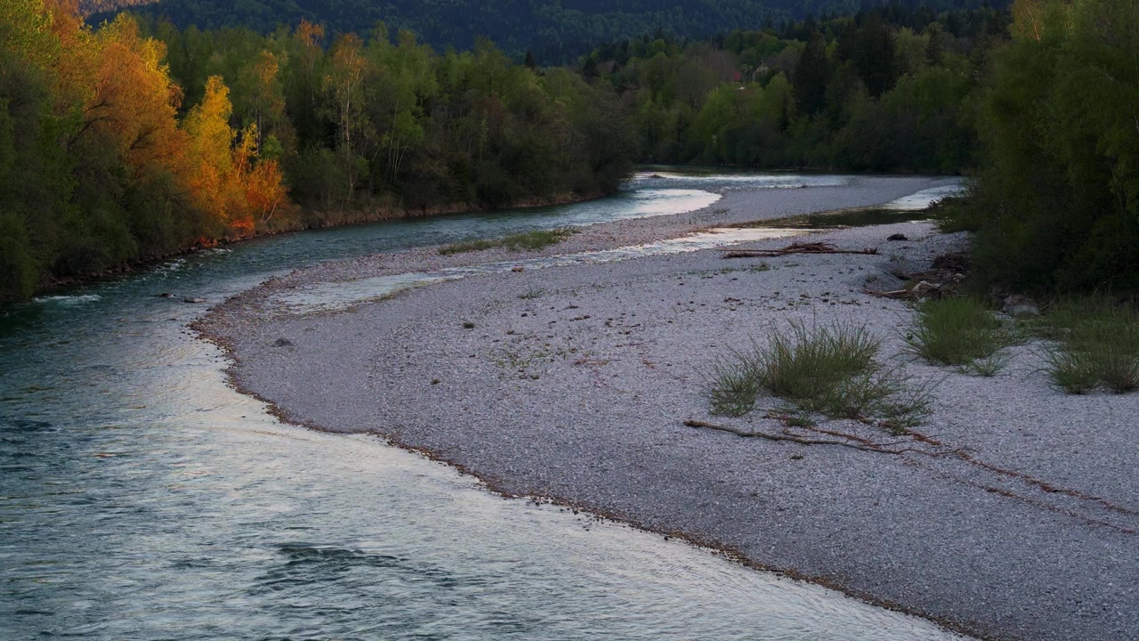 Fiume Isar turchese che scorre attraverso un letto roccioso al tramonto vicino alle Alpi bavaresi tedesche a Lenggries.