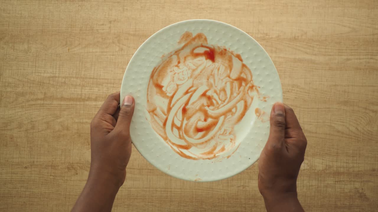 An empty plate with tomato sauce stain