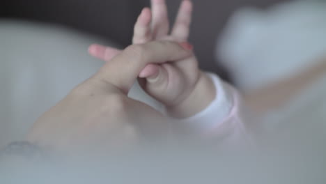 baby daughter holding mum finger