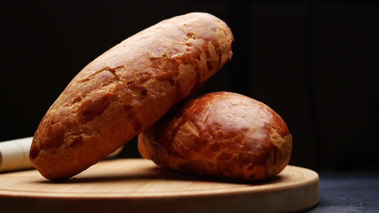 Two loaves of bread on a wooden cutting board