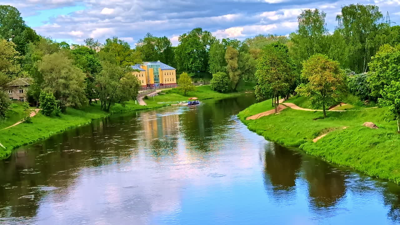 Calm Gauja River With Reflections and River Ferry Surrounded by Trees in Latvia