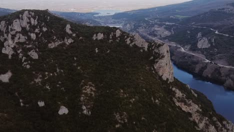 aerial flyover rocky mountains and aliakmonas river in the valley of veroia city, greece