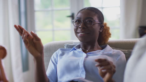 Woman-Relaxing-Lying-On-Sofa-At-Home-Interacting-With-AR-Technology