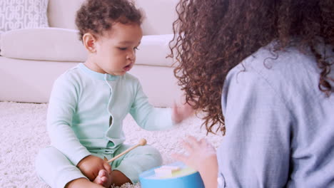 Young-black-mum-playing-xylophone-with-son-in-sitting-room