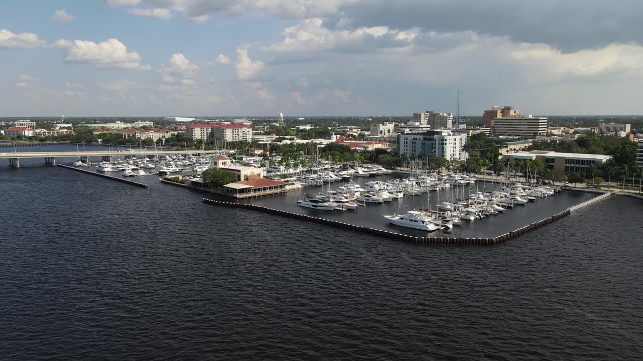 Aerial view of Bradenton marina with boats docked and the city skyline over the Manatee River. Dolly Back Day