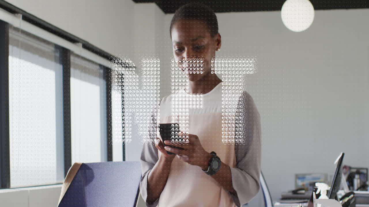 Animation of nft text banner against african american woman using smartphone at office
