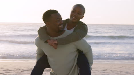 Love,-beach-and-a-couple-piggy-back-in-the-sand