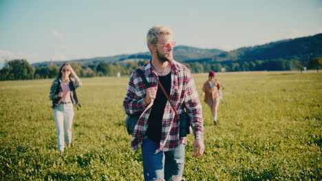 young man walking on grass with friends